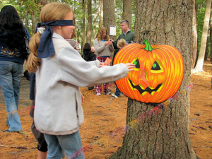 A kid touching a decorated pumpkin